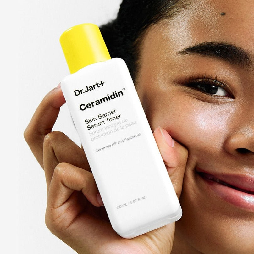 Person holding DR.JART+ Ceramidin Skin Barrier Serum Toner 150ml with a smile.
