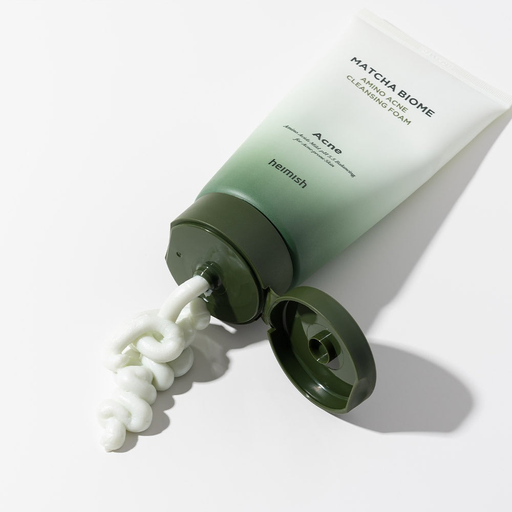 HEIMISH Matcha Biome Amino Acne Cleansing Foam 150g tube with dispenser open, demonstrating creamy texture on white background.
