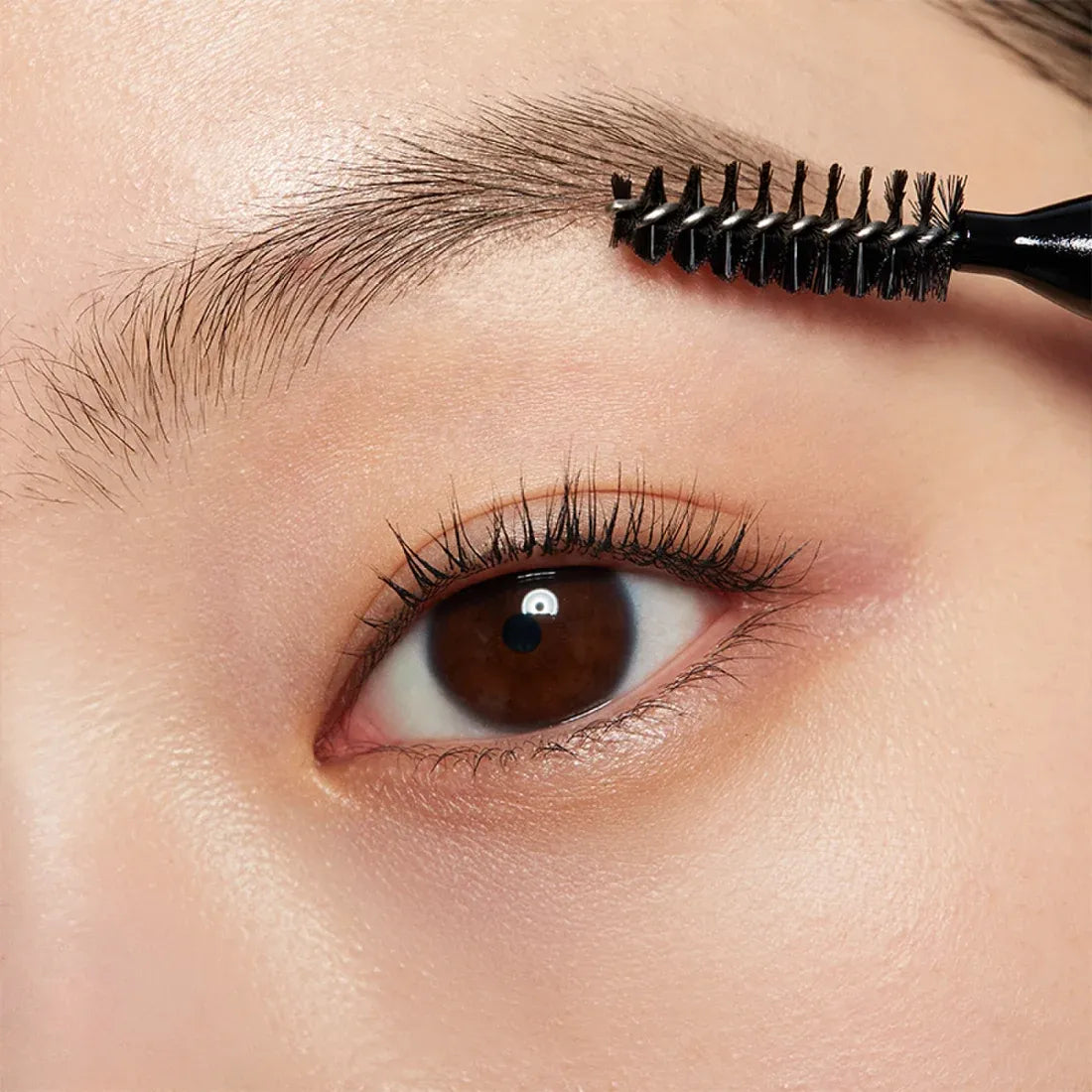 Close-up of an eyebrow being shaped using the HERA Brow Desighner Auto Pencil for precision and style.
