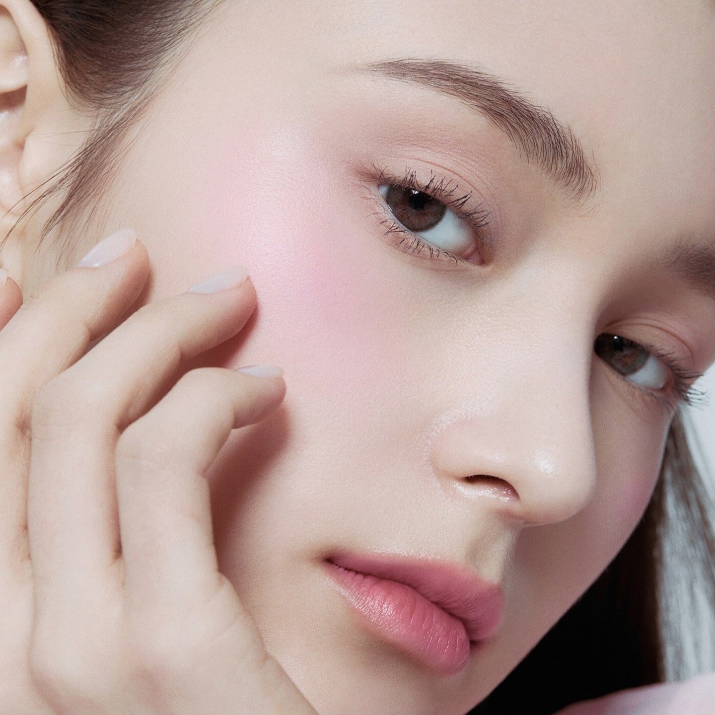 Close-up of a model wearing HERA Hera Blush 5.5g, showcasing its smooth application and natural glow on her cheek.