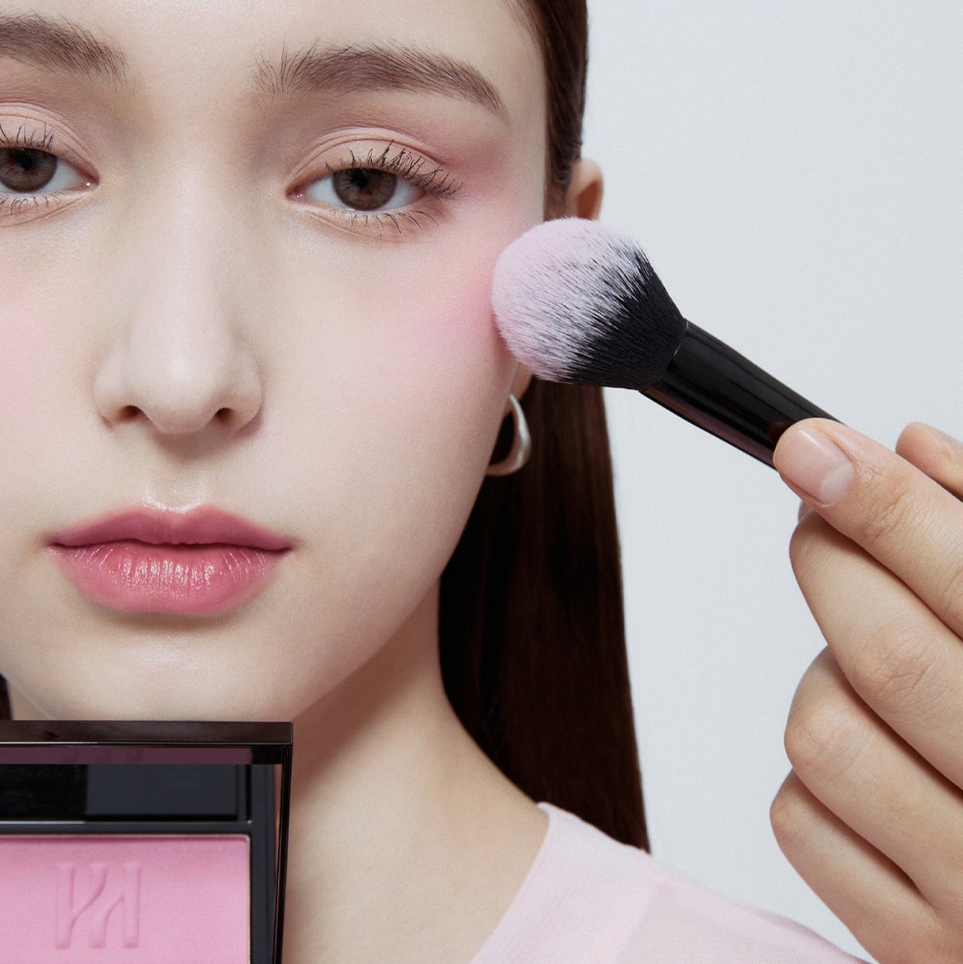 Applying HERA Hera Blush 5.5g on model's cheek using a makeup brush for a smooth, natural look.