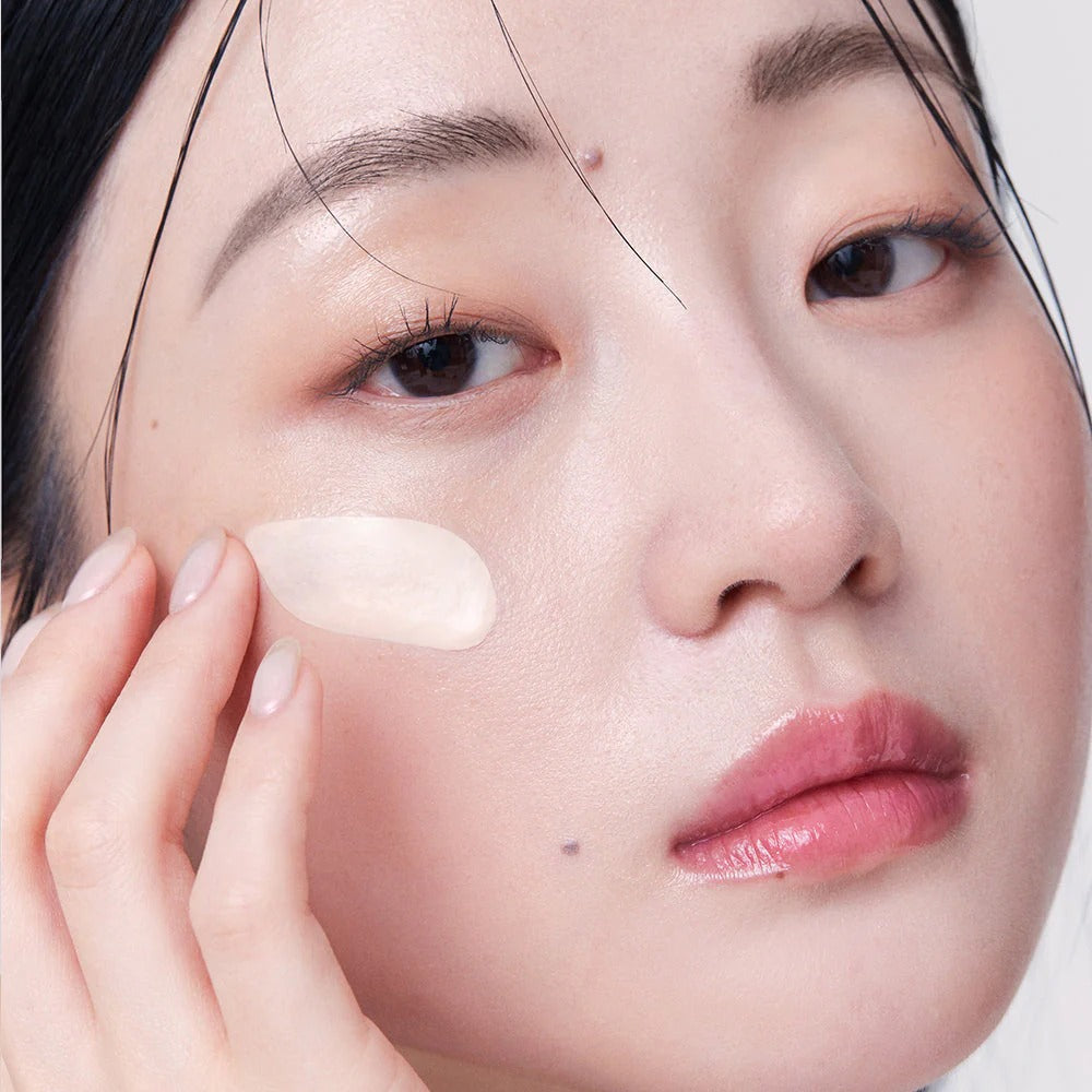 Woman applying HERA Hydrating Radiant Primer SPF30 PA++ 35ml for a smooth, glowing complexion and sun protection.
