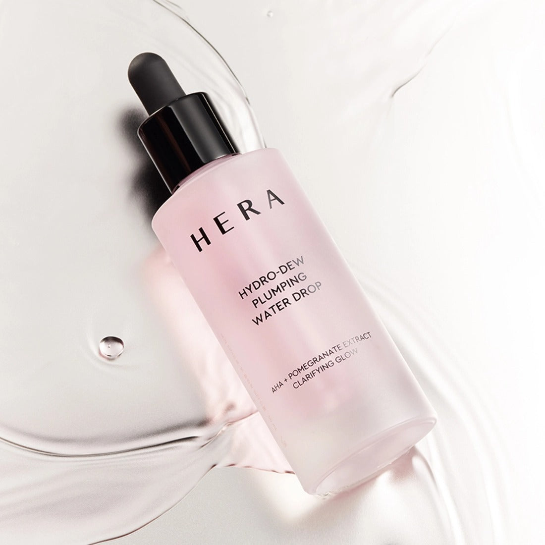 HERA Hydro-Dew Pluming Water Drop 50ml moisturizing serum bottle on a glossy surface, showcasing skincare benefits.