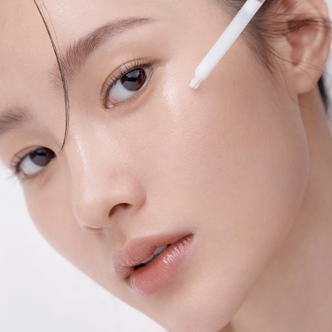 HERA Hydro-Dew Plumping Ampoule 50ml being applied to model's skin for enhanced hydration and youthful glow.