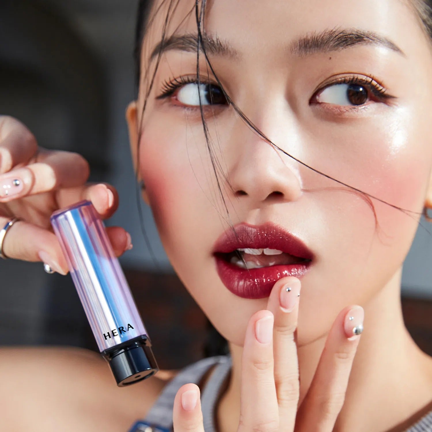 Model applying HERA Sensual Tinted Shine Stick 3.5g for radiant lips