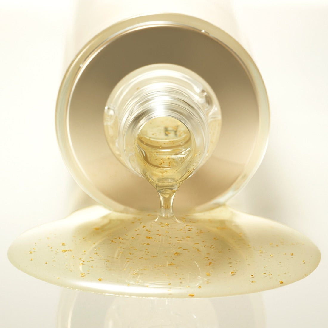 Close-up of HERA Signa Skin refreshing Water 180ml, showcasing its texture and golden flecks as it pours elegantly from the bottle.