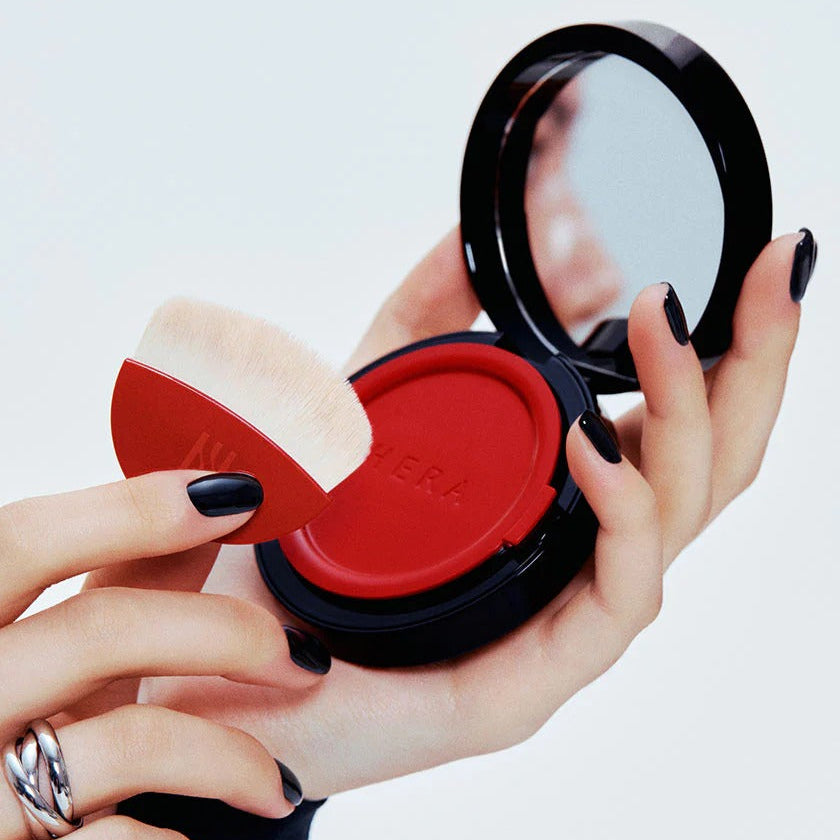 HERA Skin Tint Comfy Spreader SPF50+ PA++++ 15g with application brush and compact mirror, showcasing premium skincare product.