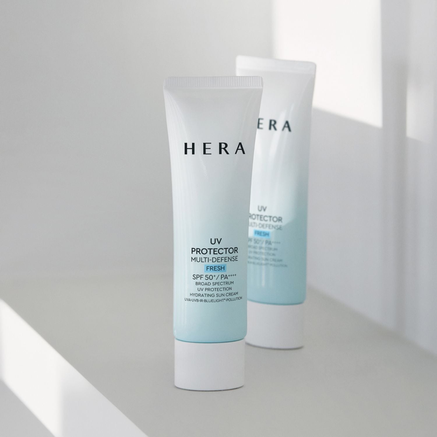 HERA UV Protector Multi-Defense Fresh SPF50+PA++++ 50ml in sleek white packaging on a minimalist white surface.