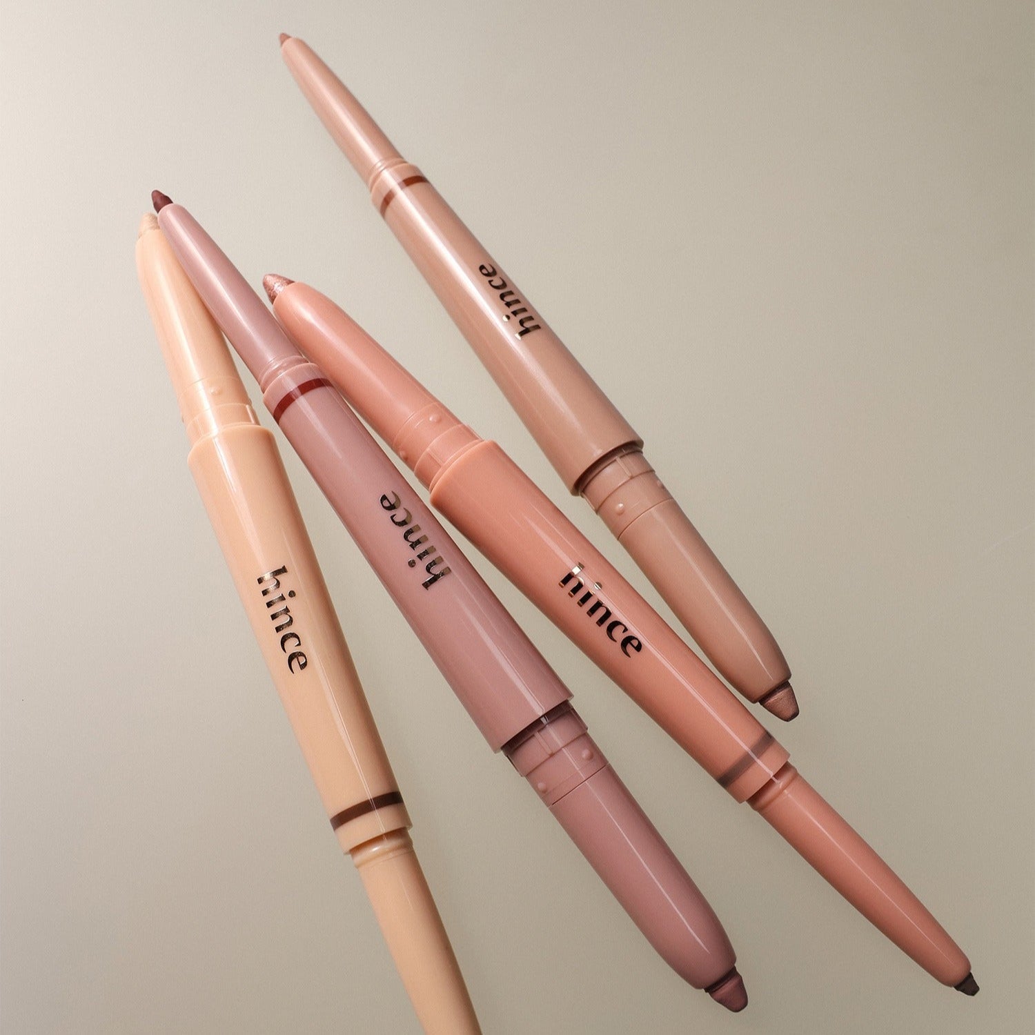 HINCE Depth Dual Color Stick showcasing four dual-ended makeup sticks in neutral tones on a textured backdrop.