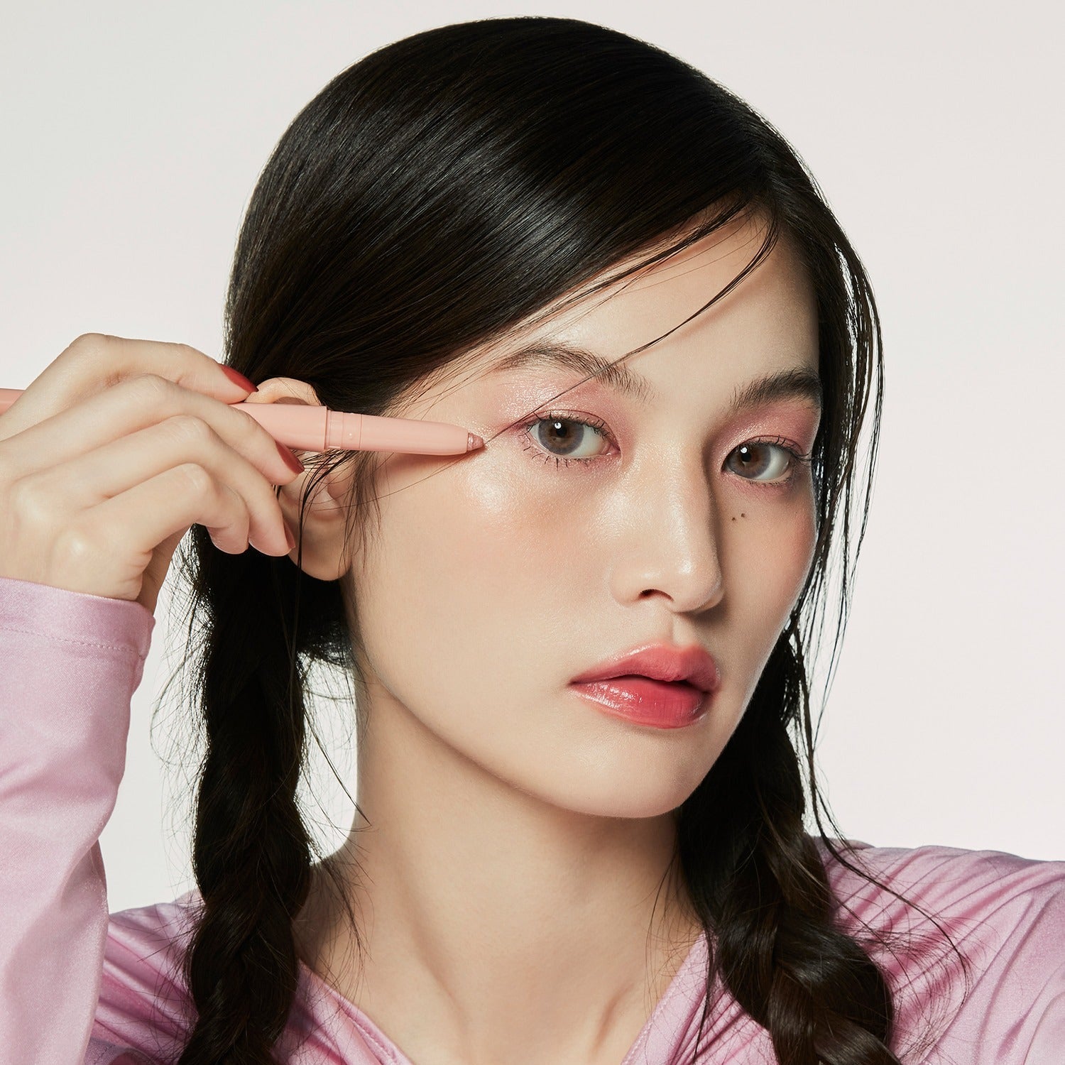 Person applying HINCE Depth Dual Color Stick makeup in natural light, showcasing its smooth application and vibrant color finish.