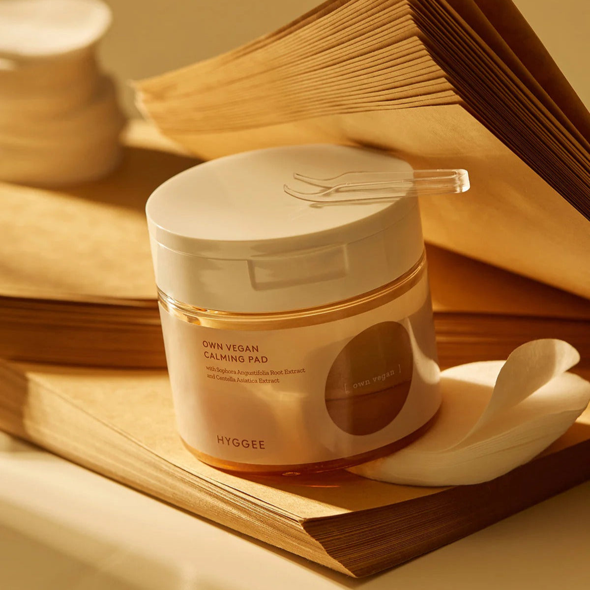 HYGGEE Own Vegan Calming Pad 70 Pads displayed elegantly on a book with soothing aesthetic.