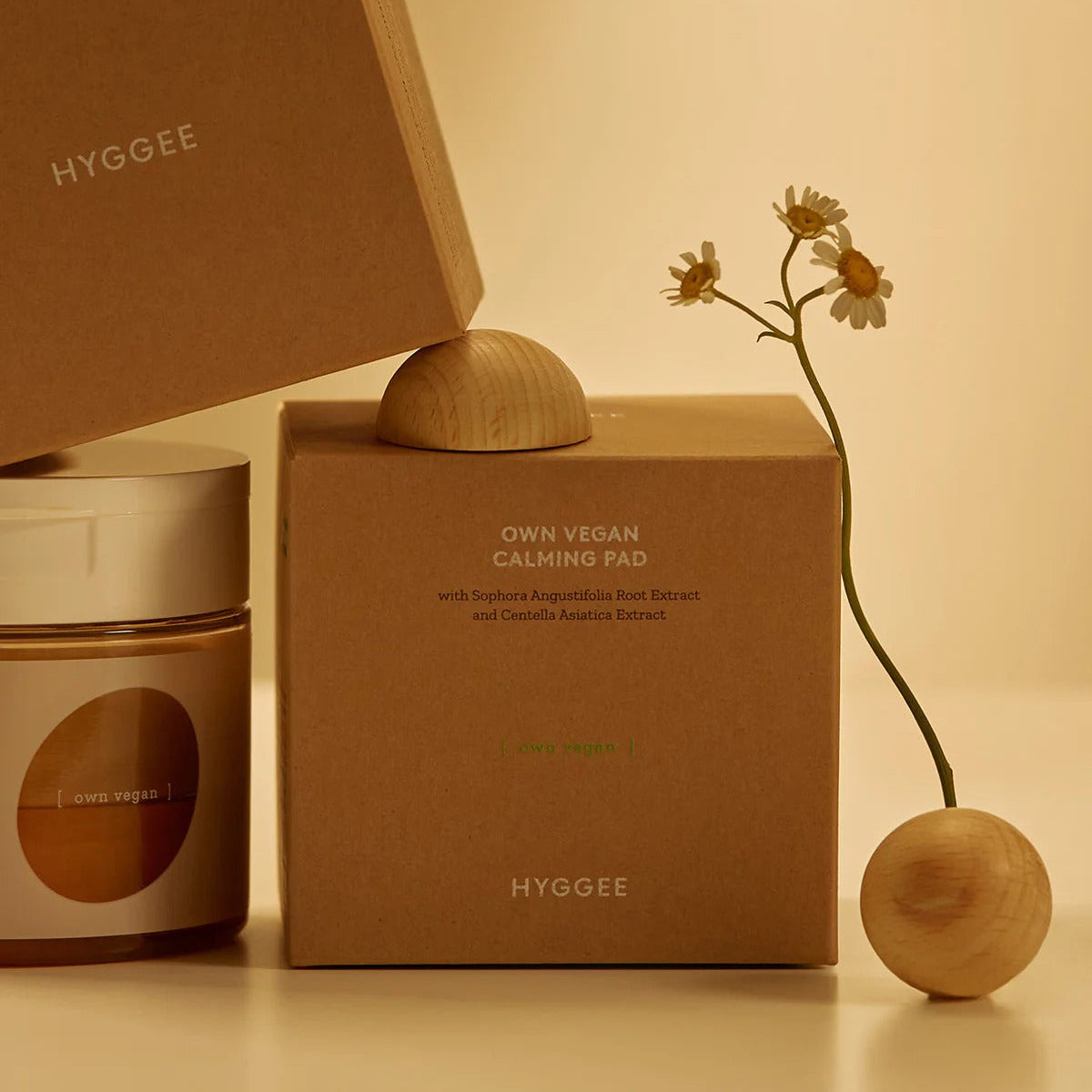 HYGGEE Own Vegan Calming Pad 70 Pads in elegant packaging with delicate flower for soothing skincare experience.