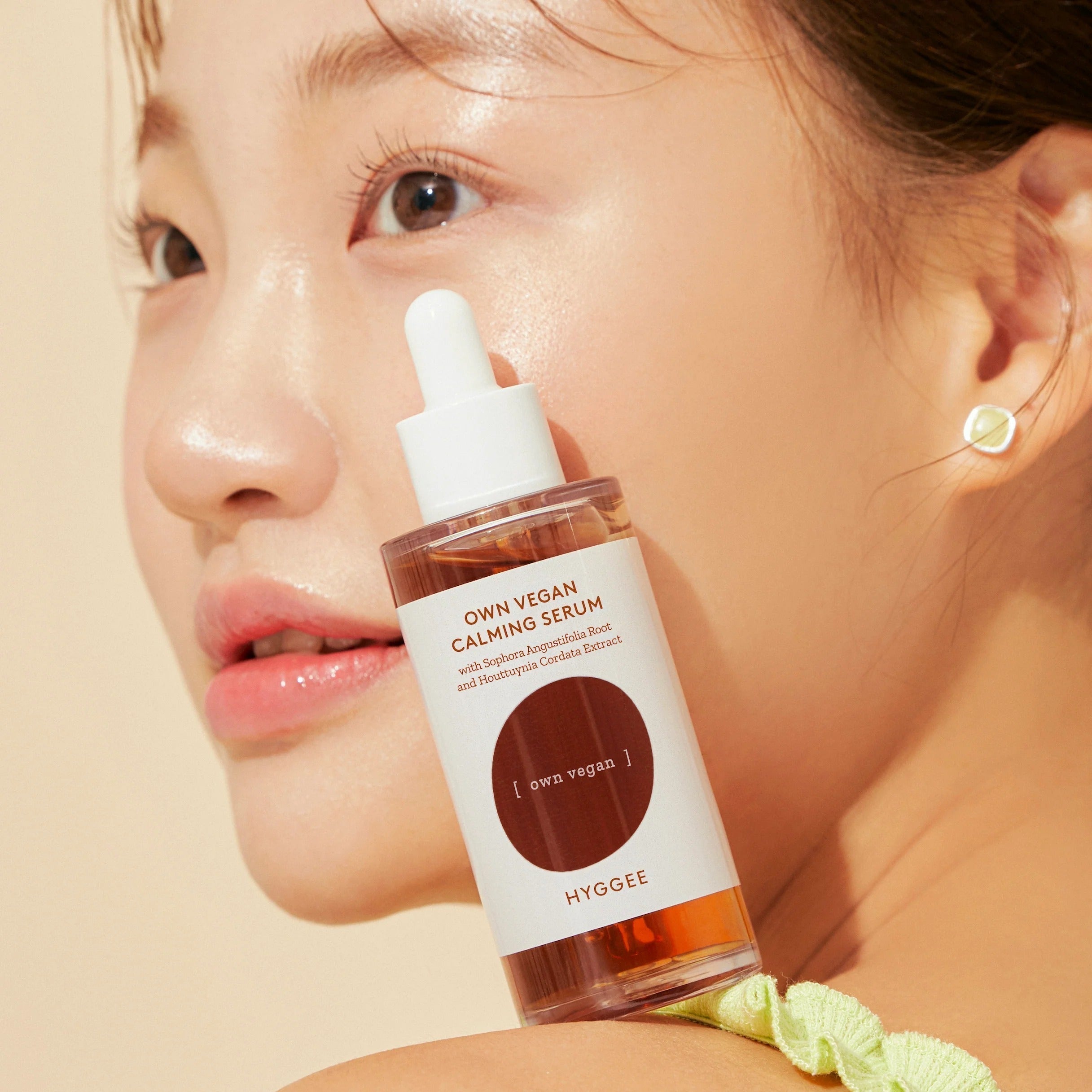 HYGGEE Own Vegan Calming Serum 50ml bottle against skin for a soothing skincare routine.
