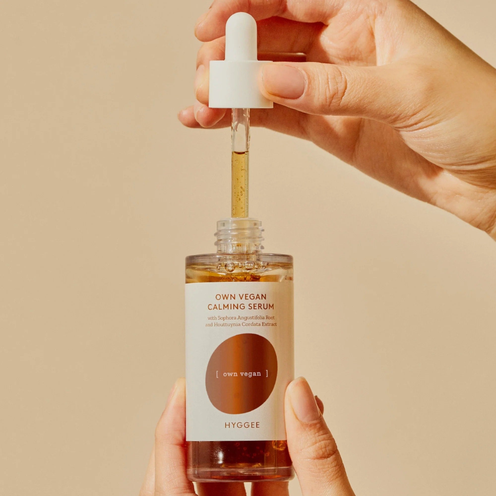 HYGGEE Own Vegan Calming Serum 50ml being dispensed from dropper, showcasing relaxing skincare solution.