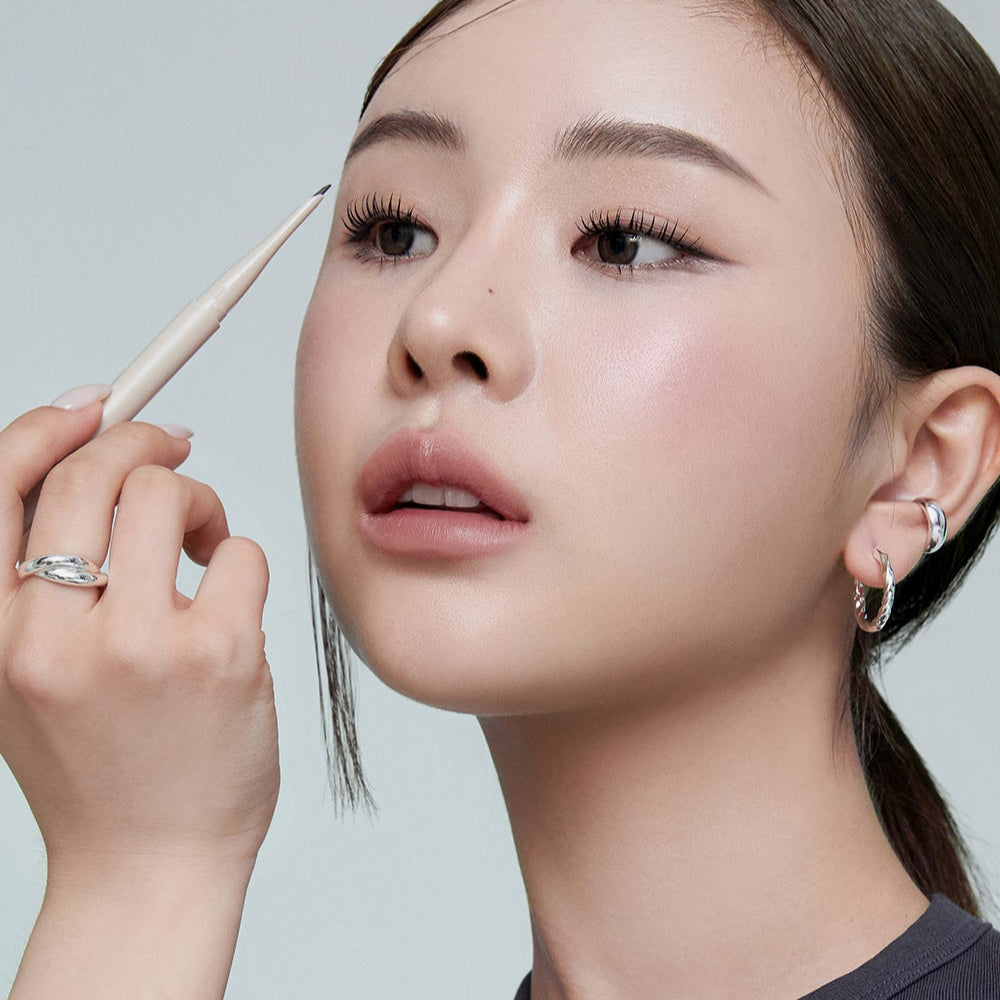 Woman applying HEART PERCENT Dot On Mood Edge and Flat Eyebrow makeup for perfect brows.