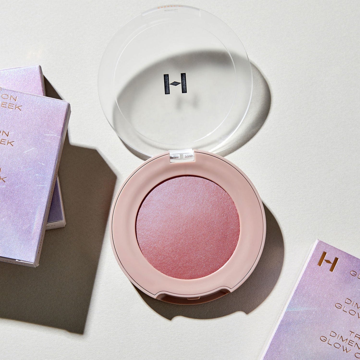 HINCE True Dimension Glow Cheek in compact with packaging, showcasing its rosy hue and sleek design.